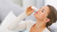 young woman using nose drops